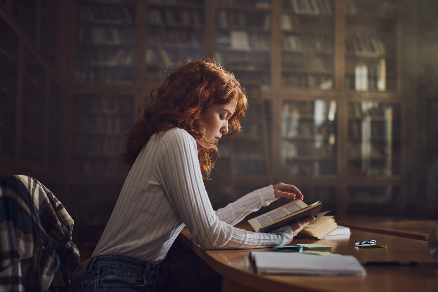 A writer immersed in thoughts, pen in hand.