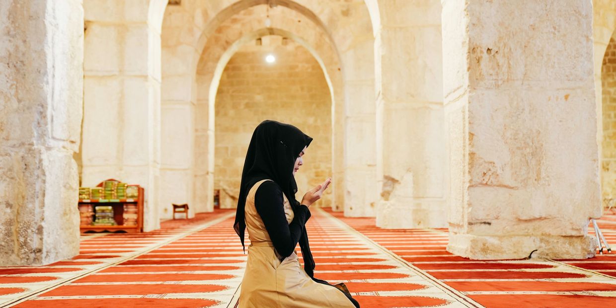 Woman praying inside a mosque.