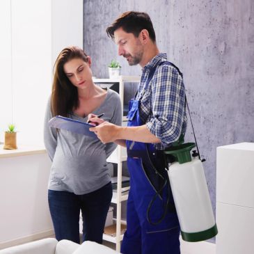 Pest control worker consulting with a woman.