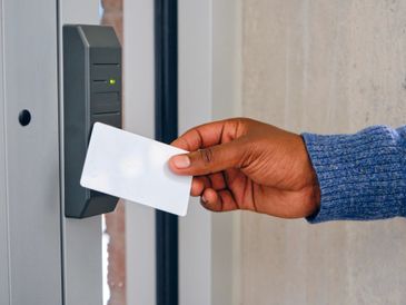 Person using a key card to access a secured door.