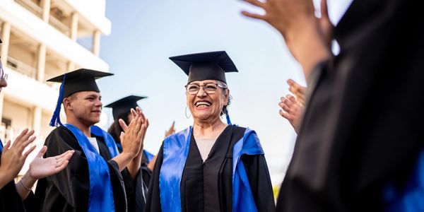 Happy graduates celebrating outdoors in caps and gowns.