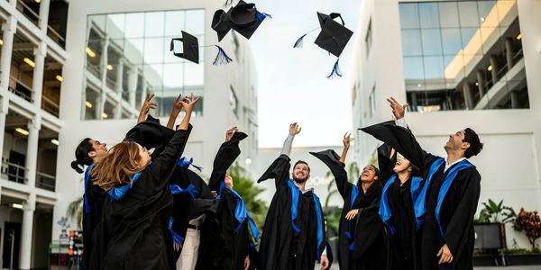A group of graduates throwing their caps into their air