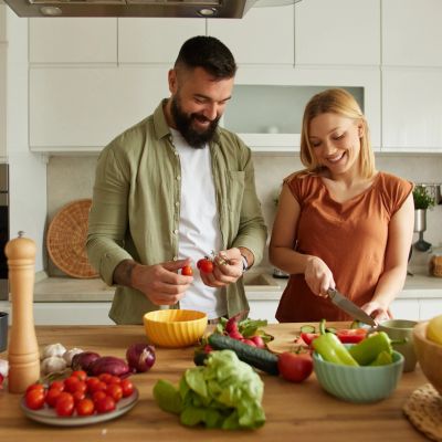 Couple preparing fresh vegetables in kitchen.
