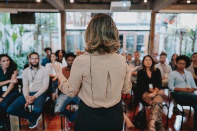 Woman speaking to an attentive audience in a seminar.