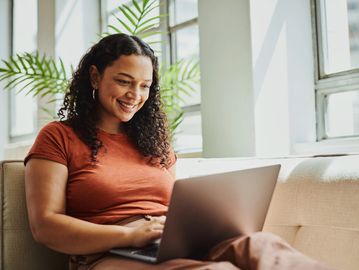 Woman working happily on laptop at home.