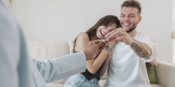 Happy couple receiving house keys from a real estate agent.