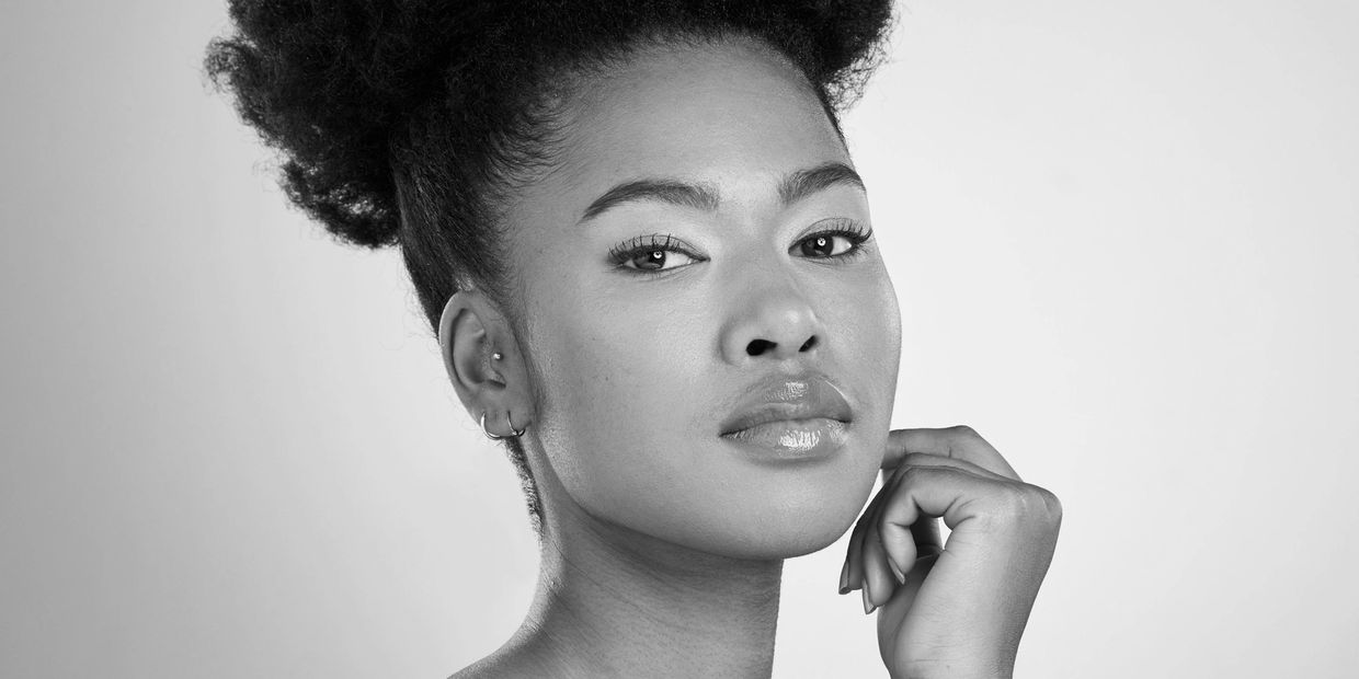 Confident woman with natural afro hairstyle and glowing skin.