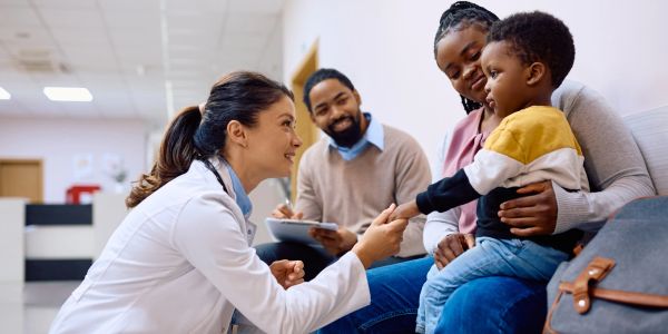 Doctor shaking hands with a child at a clinic.