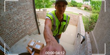 Video doorbell footage of a person approaching a front door with packages visible on the porch