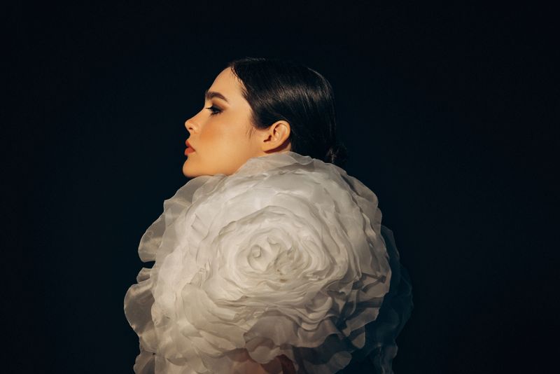 Studio shot of young beautiful woman wearing amazing dress with flower