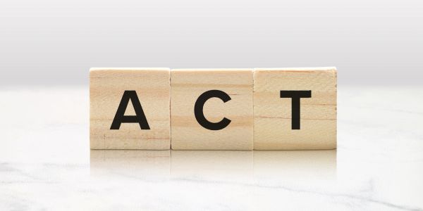 Wooden blocks spelling the word 'ACT'.