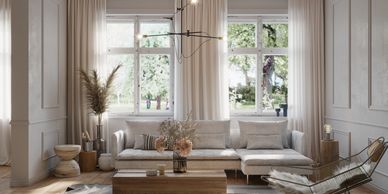 Cozy living room with neutral tones and natural light from large windows.