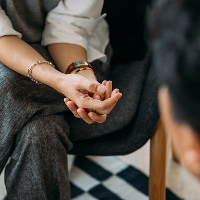 Two people engaged in a serious conversation, focusing on hands and body language.