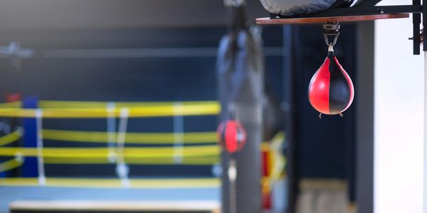 Three young male boxers relax and chat in a gym.