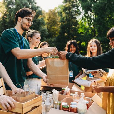 Volunteers distributing food and supplies outdoors during a community event.
