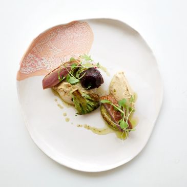 Gourmet dish artfully plated with microgreens and sauce.