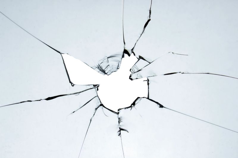 Old broken glass. A hole in the window on a white background crack. Texture for design