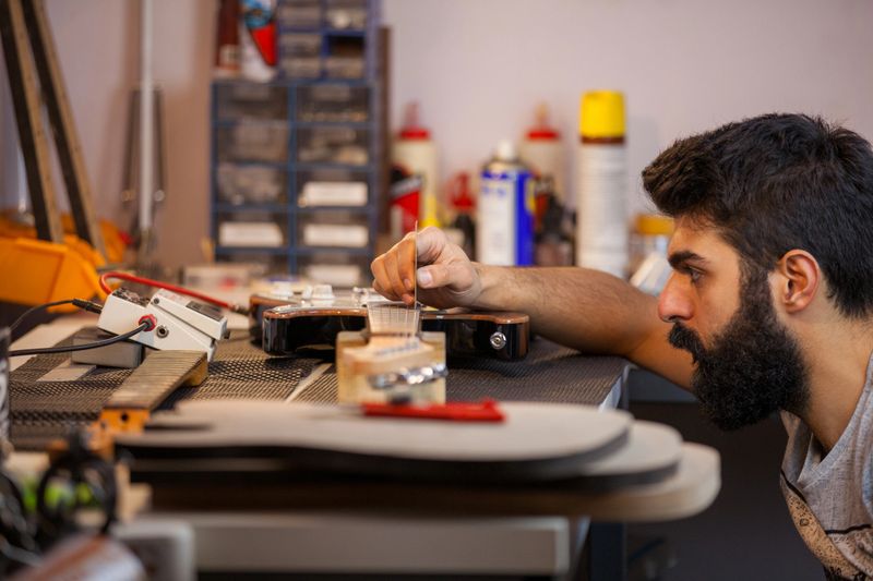 Guitar luthier accurately calibrates.
