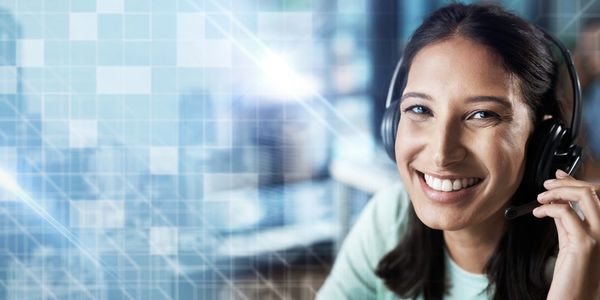 Smiling woman wearing a headset in a professional setting.