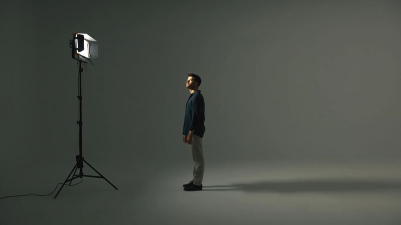 Young man in front of a LED light in a studio.
