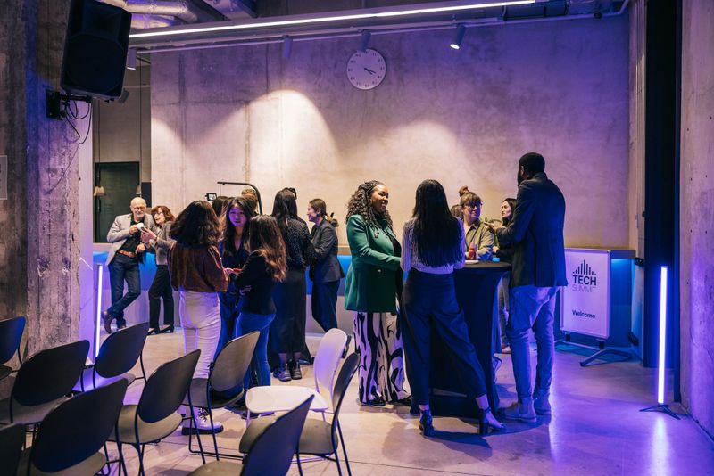 Candid shot of diverse and multi ethnic business people and entrepreneurs. Changing fresh ideas and contacts after successful Tech conference at networking event.