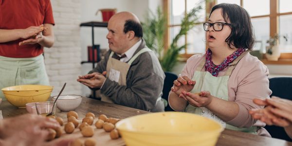 Blind people in a cooking class, learning how to cook.