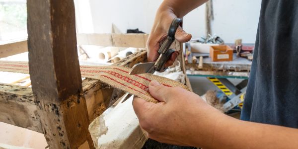 Person cutting fabric with scissors.