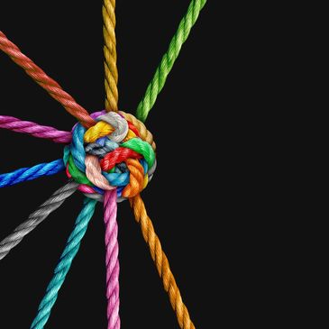 Colorful ropes tied together in a tight knot on black background.