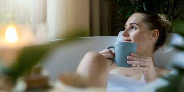 Woman enjoying a cup in a relaxing bath.