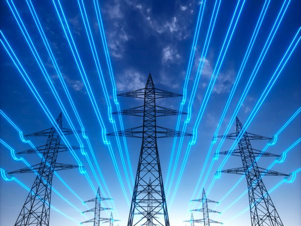 Electricity pylons with glowing blue power lines against a twilight sky.