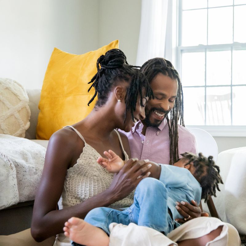Mother and father dote on toddler son while spending quality time together at home