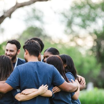Group hug outdoors among friends.