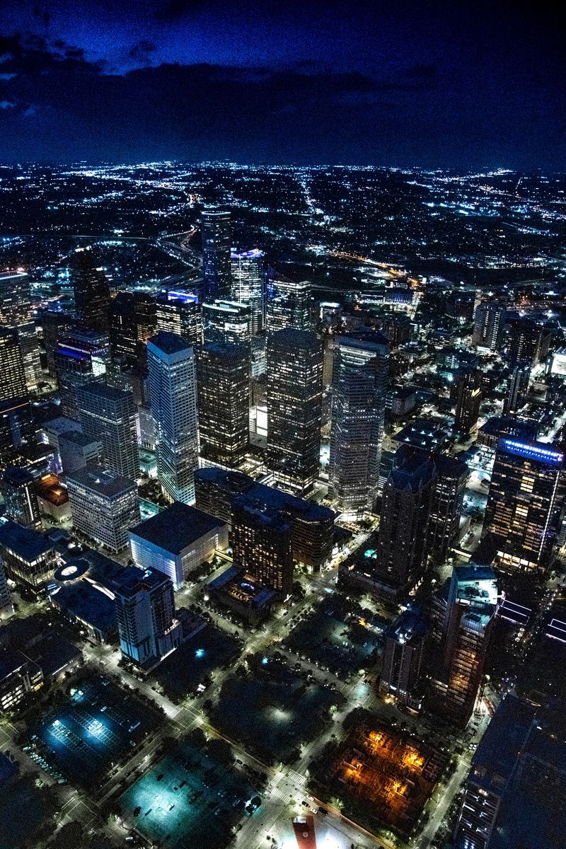 The illuminated streets and buildings of downtown Houston, Texas on an early spring evening just after sunset shot from an altitude of about 1000 feet directly over the city.