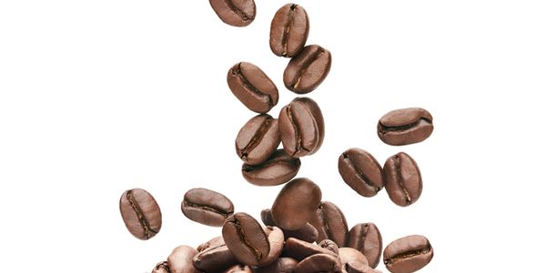 Close-up of roasted coffee beans falling on a pile.