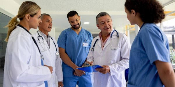 Doctors and nurses discussing patient care in hospital.