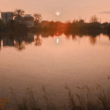 Sunset over a calm river with reflections.