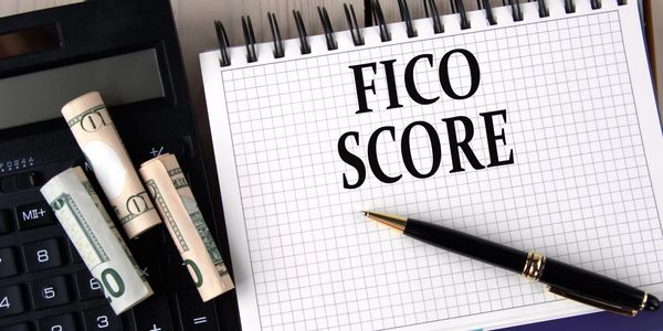 Text Written Fico score with pen paper dollar and calculator
