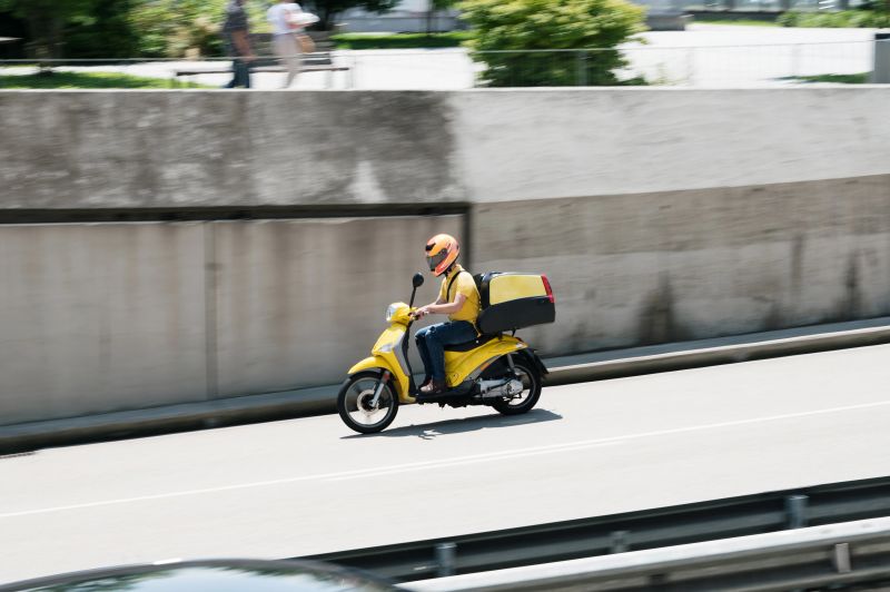 A delivery motorbike in motion in a city