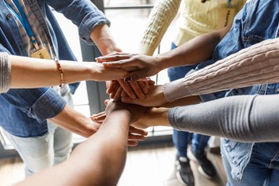 Group joining hands in unity.