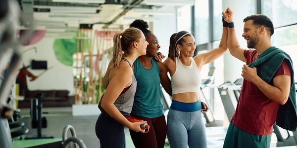 Group of friends celebrating a workout success at the gym.