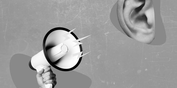 Megaphone amplifying sound towards a large ear on a blue background.