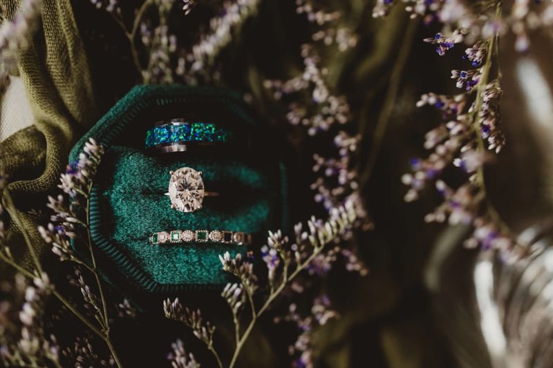 Emeralds and diamonds in wedding rings with green velvet ring box