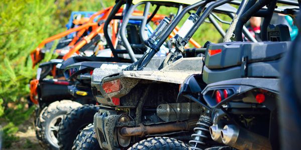 Line of off-road vehicles parked outdoors.