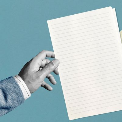Hand holding a blank lined sheet of paper.