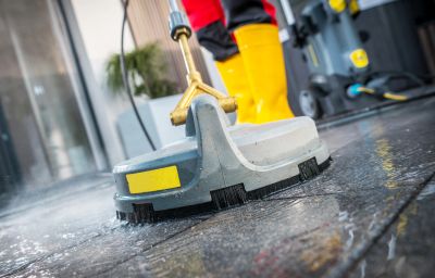 Surface cleaning machine washing a wet floor.