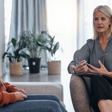 Therapist attentively listening to a patient in a counseling session.