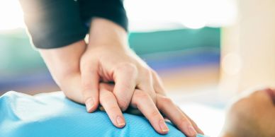 Hands performing CPR chest compressions.