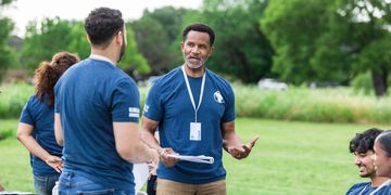 Volunteers coordinating outdoors wearing blue shirts.
