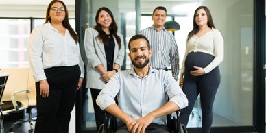 Five diverse professionals posing confidently in an office.