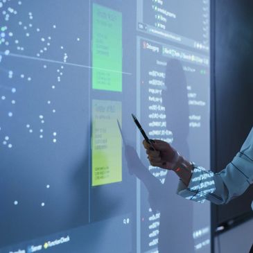 A woman presents visualized data during a client training on a digital learning board.
